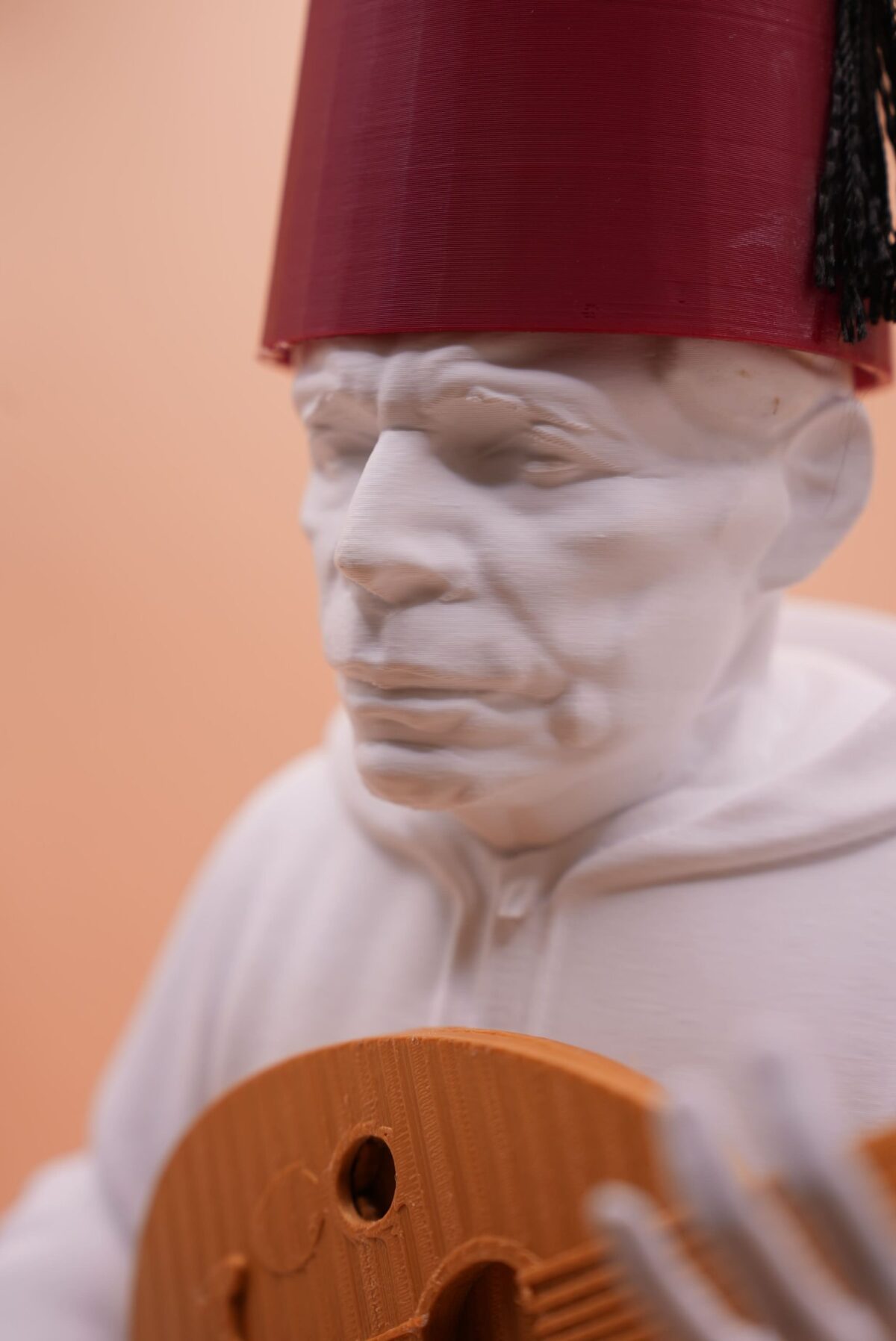 Statue 3D imprimée en PLA représentant Houssine Toulali, maître du Malhoun marocain, portant fez rouge et tenant un oud.